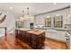 Spacious kitchen features custom cabinets, large central island, and stainless steel appliances with staircase nearby at 1027 S Fillmore Way, Denver, CO 80209