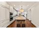Large kitchen area with an island with barstool seating and chef appliances with neutral color palette at 1027 S Fillmore Way, Denver, CO 80209