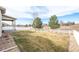 Large backyard featuring a well-maintained lawn, white picket fence, and distant views at 2317 Winding Dr, Longmont, CO 80504