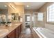 This primary bathroom has dual sinks, a soaking tub, and a glass shower at 2317 Winding Dr, Longmont, CO 80504