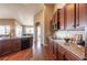 Kitchen with dark wood cabinets and views to dining room and sunlit outdoor living at 2317 Winding Dr, Longmont, CO 80504