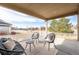 Covered patio with comfortable seating, a small table, and a view of the backyard and beyond at 2317 Winding Dr, Longmont, CO 80504