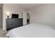 Bright bedroom featuring a dresser, television, and view to an adjacent room at 8012 S Cedar St, Littleton, CO 80120