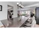 Bright dining room with modern chandelier, opening to the kitchen and featuring a large window view to the living room at 8012 S Cedar St, Littleton, CO 80120