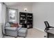 Cozy home office featuring a comfortable chair, ottoman, and built-in bookshelves at 8012 S Cedar St, Littleton, CO 80120