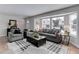 Bright and airy living room with gray furnishings, hardwood floors, and large windows at 8012 S Cedar St, Littleton, CO 80120