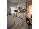 Galley kitchen with white cabinets and wood-look flooring at 3327 Navajo St, Denver, CO 80211