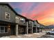 Modern townhome exterior featuring stone pillars, balconies, and scenic mountain backdrop at dusk at 2115 Hummingbird Way # 105, Georgetown, CO 80444