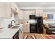 Modern kitchen showcases sleek countertops and black appliances, adjacent to a living area at 2115 Hummingbird Way # 105, Georgetown, CO 80444