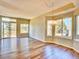 Bright living room with hardwood floors, large windows, and sliding glass doors to a deck at 9711 Millstone Ct, Highlands Ranch, CO 80130