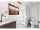 A bathroom with a window, shower, toilet, sink and gray counters is seen at 1101 E 7Th Avenue Cir, Broomfield, CO 80020