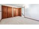 A bedroom with three closet doors and an open doorway to the stairway is carpeted at 1101 E 7Th Avenue Cir, Broomfield, CO 80020