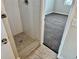 Modern bathroom with a large walk-in shower and grey tile flooring at 1244 Racine St, Aurora, CO 80011