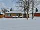 Brick ranch home with snowy yard and attached garage at 1244 Racine St, Aurora, CO 80011