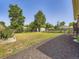 Fenced backyard featuring a grass lawn, mature trees, shed, and mulch ground cover at 10736 Logan Ct, Northglenn, CO 80233