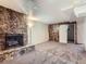 Basement with stone fireplace, barn door, and neutral carpet with wooden accent wall at 10736 Logan Ct, Northglenn, CO 80233