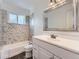 Bathroom features white marbled shower surround and floors, a shower/tub combo, and a white vanity at 10736 Logan Ct, Northglenn, CO 80233