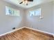 Well-lit bedroom with a ceiling fan, beautiful hardwood floors, and two windows allowing ample natural light at 10736 Logan Ct, Northglenn, CO 80233