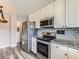 Modern kitchen featuring stainless steel appliances, granite countertops, and gray backsplash at 10736 Logan Ct, Northglenn, CO 80233