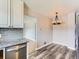 Stylish kitchenette with grey cabinets, a granite countertop, and a modern chandelier above a dining area at 10736 Logan Ct, Northglenn, CO 80233