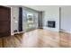 Cozy living room features hardwood floors, a decorative fireplace, and a large window at 10736 Logan Ct, Northglenn, CO 80233