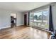 Open living room with hardwood floors, large window, and access to the kitchen at 10736 Logan Ct, Northglenn, CO 80233