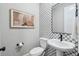 Elegant powder bathroom features a decorative backsplash, toilet and pedestal sink at 17075 W 92Nd Loop, Arvada, CO 80007