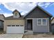 New build home featuring a partial beige and grey exterior with an attached two-car garage and covered porch at 17075 W 92Nd Loop, Arvada, CO 80007