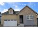 Charming exterior of a two-story home featuring stone and siding, complete with an attached garage and inviting front entrance at 17075 W 92Nd Loop, Arvada, CO 80007