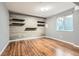 Finished basement area with wood-look floors, modern floating shelves, and a window at 10460 Ketchwood Ct, Highlands Ranch, CO 80130