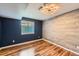 Finished basement featuring wood-look flooring, neutral and blue walls, and a large window at 10460 Ketchwood Ct, Highlands Ranch, CO 80130