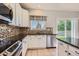 Modern kitchen featuring mosaic backsplash, granite countertops, stainless steel appliances, and a window at 10460 Ketchwood Ct, Highlands Ranch, CO 80130