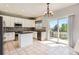 Modern kitchen featuring white cabinetry, mosaic backsplash, granite countertops, island, and sliding glass door at 10460 Ketchwood Ct, Highlands Ranch, CO 80130
