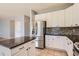 Modern kitchen features white cabinetry, mosaic backsplash, granite countertops, and stainless steel appliances at 10460 Ketchwood Ct, Highlands Ranch, CO 80130