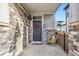 Cozy front porch with stone accents, featuring a decorated front door, rocking chair and welcoming signage at 765 N Shawnee St, Aurora, CO 80018