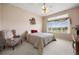 A bedroom features a large window with scenic views, neutral colors, and a cozy armchair at 11558 Pine Hill Way, Parker, CO 80138