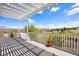 A covered deck with white railings offers expansive views of the green landscape and sunny sky at 11558 Pine Hill Way, Parker, CO 80138