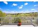 A balcony with white railings offers expansive views of the green landscape under a sunny, blue sky at 11558 Pine Hill Way, Parker, CO 80138