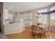 Bright kitchen and dining area featuring white cabinets, stainless appliances, hardwood floors, and natural light at 11558 Pine Hill Way, Parker, CO 80138