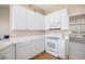 A bright kitchen features white cabinets, appliances, and hardwood floors at 11558 Pine Hill Way, Parker, CO 80138