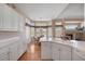 Bright kitchen featuring white cabinets, stainless steel appliances, light countertops, and wood flooring at 11558 Pine Hill Way, Parker, CO 80138