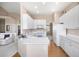 A well-lit kitchen with white cabinets, countertops, and modern appliances; adjoining living room at 11558 Pine Hill Way, Parker, CO 80138