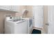 Functional laundry room featuring newer washer and dryer units, tile flooring and a utility sink at 11558 Pine Hill Way, Parker, CO 80138