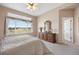 Spacious bedroom with large window, ceiling fan, and vintage dresser with decorative mirror at 11558 Pine Hill Way, Parker, CO 80138