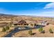 Estate view with a long driveway, grand home, separate barn, and sprawling landscape at 2785 Bears Den Dr, Sedalia, CO 80135