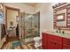 Bright bathroom features glass enclosed shower, wood-like flooring, and a red vanity with granite counters at 2785 Bears Den Dr, Sedalia, CO 80135