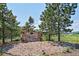 Stone community sign at Bear's Den, set amongst mature pine trees at 2785 Bears Den Dr, Sedalia, CO 80135