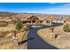 Grand home with rustic exterior, circular driveway, detached garage, and mountain views at 2785 Bears Den Dr, Sedalia, CO 80135