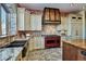 Gourmet kitchen boasts brick accent wall, custom cabinets, and a red gas range at 2785 Bears Den Dr, Sedalia, CO 80135