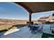 Covered patio with outdoor dining set and scenic views of the surrounding landscape at 2785 Bears Den Dr, Sedalia, CO 80135